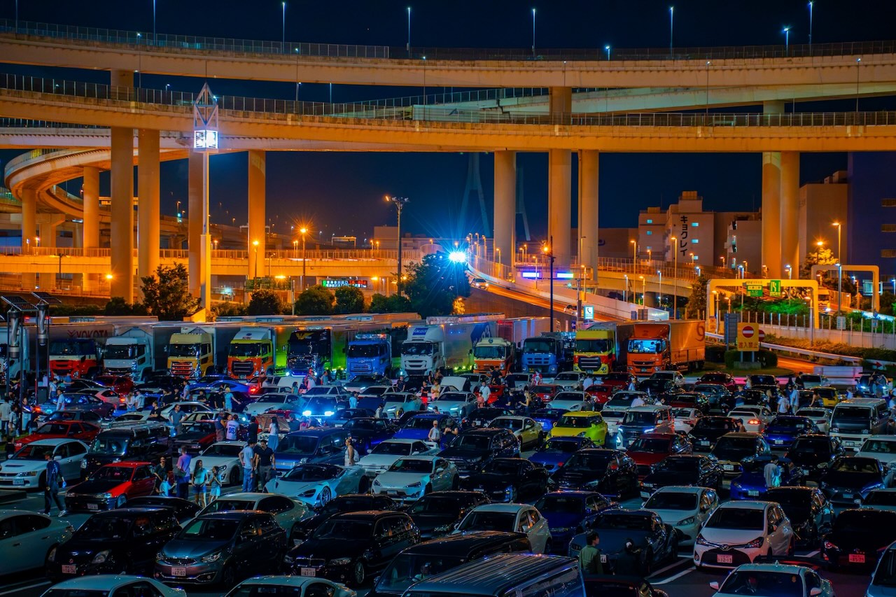 Wide view of Daikoku PA car meet at night under the Yokohama Bay Bridge interchange