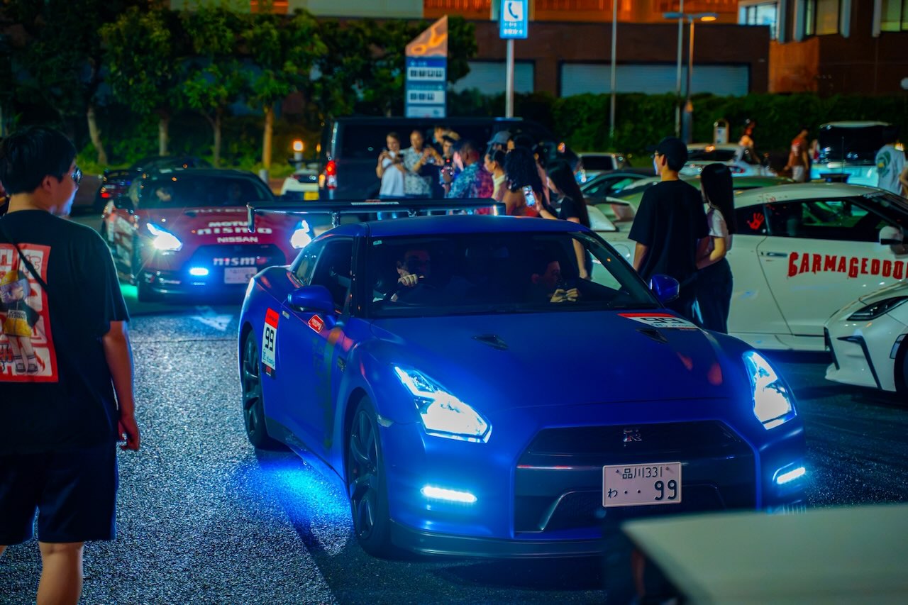 Blue Nissan GT-R R35 alongside a red Nismo R35 at the Daikoku PA night meet