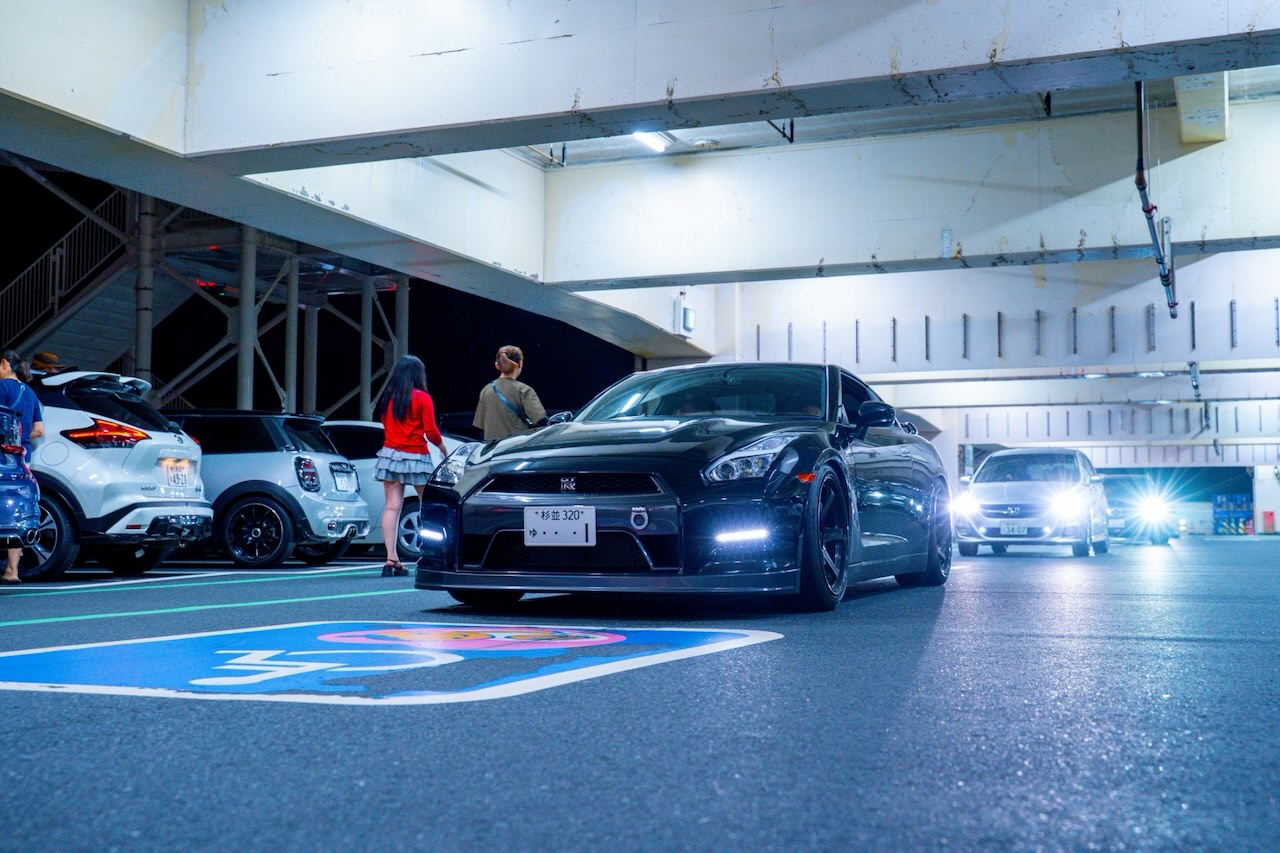 Black Nissan GT-R R35 front three-quarter view at night in Tokyo